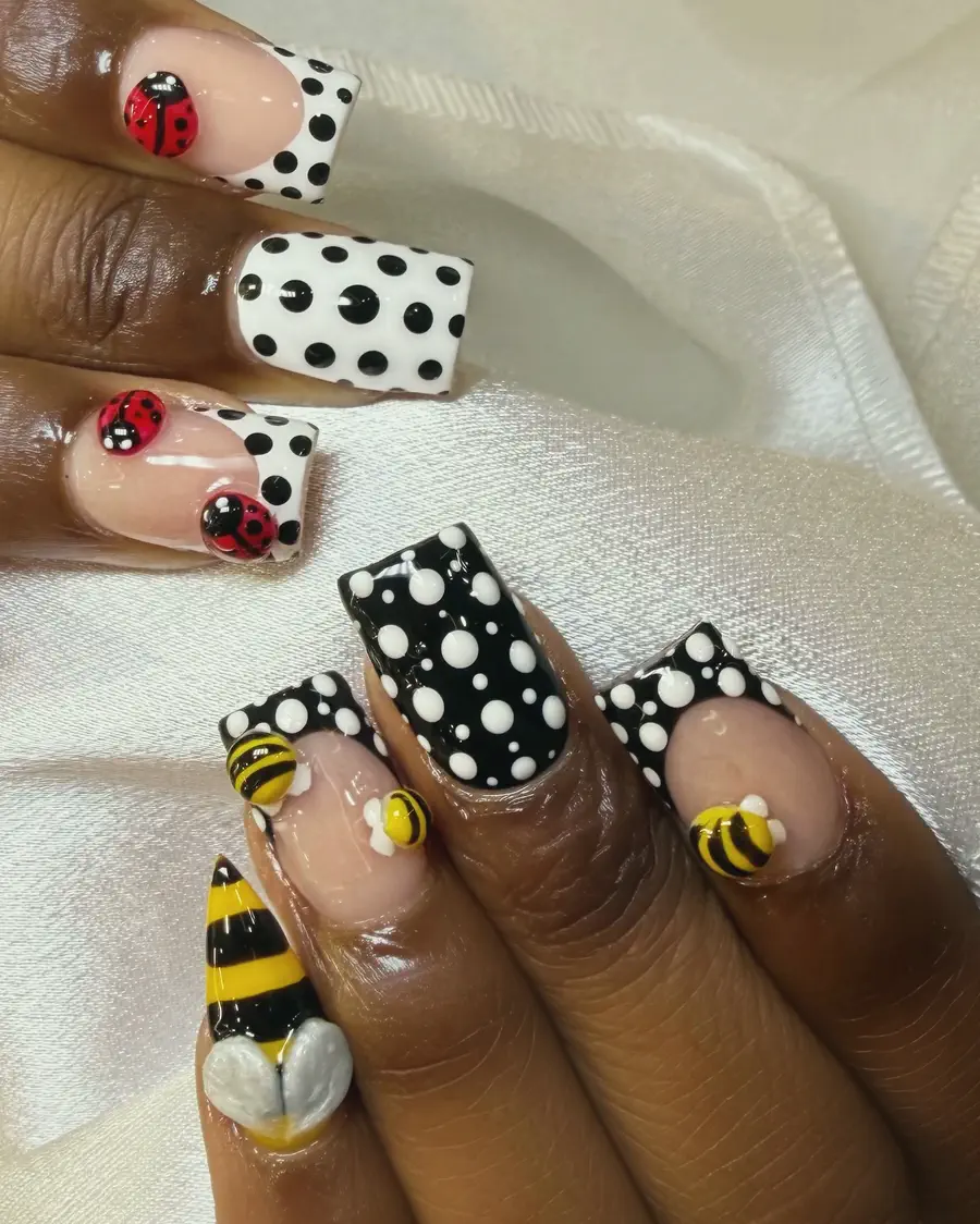 Black and white polka-dot nails with 3D bees and a ladybug