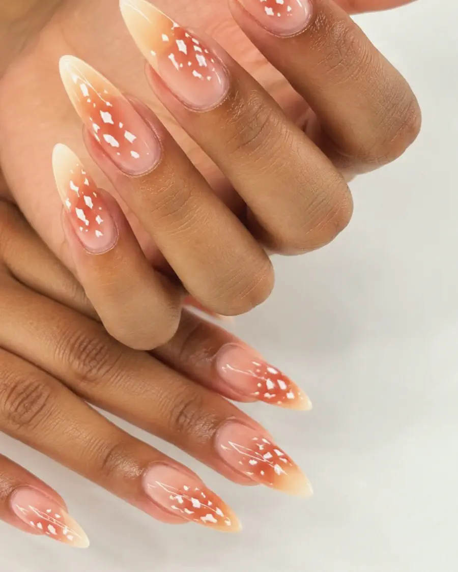 Long almond nails in a peach-to-white ombre with small white dots