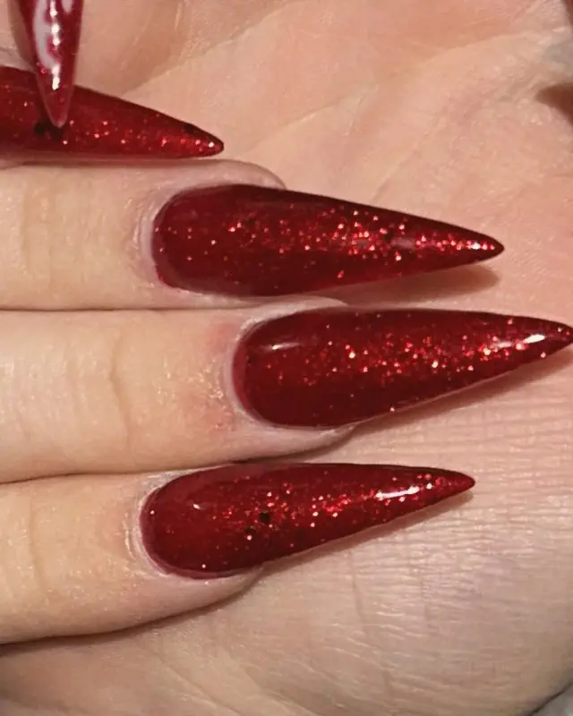 Four long red glitter stiletto nails